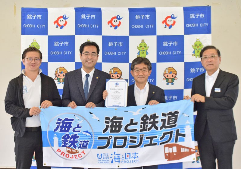 認定証を手にする越川信一市長（左から３人目）ら＝銚子市
