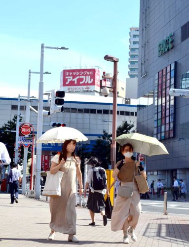 強い日差しに日傘を差す通行人の姿が目立った＝１日午後２時ごろ、ＪＲ船橋駅前