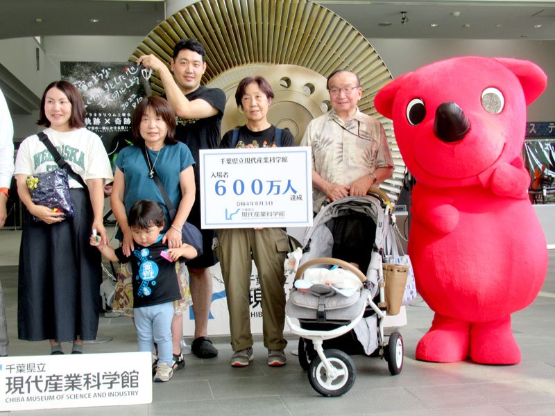 入館者６００万人目となり記念撮影する西川さん一家。県のマスコットキャラクター、チーバくん（右端）もお祝いに＝市川市の県立現代産業科学館
