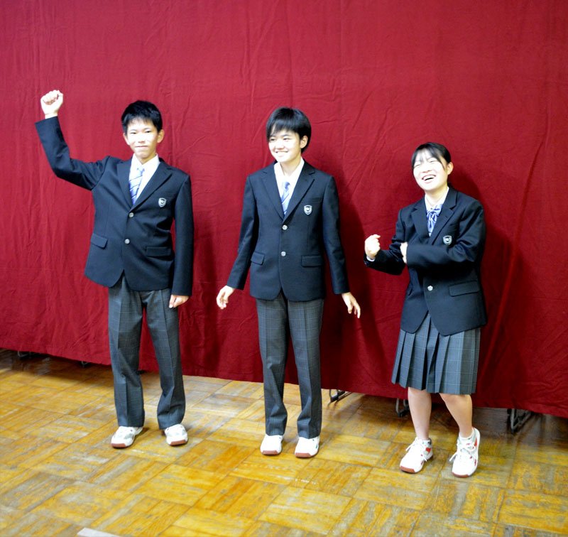 男女を問わないデザインのスラックス・ネクタイの新制服を試着した生徒（左の２人）。スカートやリボン（右）も性別に関係なく選択できる＝１日、船橋市立行田中