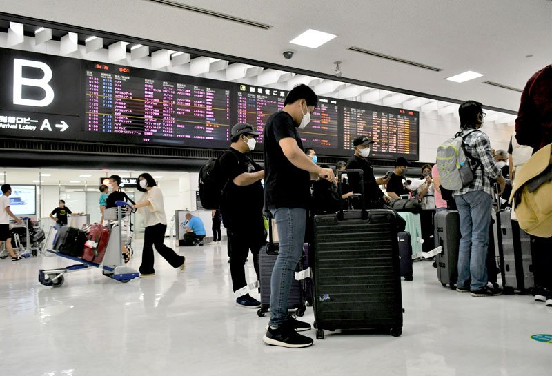 訪日観光団体ツアーの外国人客や帰国者が行き交う成田空港の国際線到着ロビー＝７日午前８時５０分ごろ