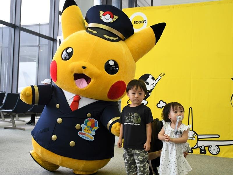 子どもたちと記念撮影するピカチュウ＝９日、成田空港
