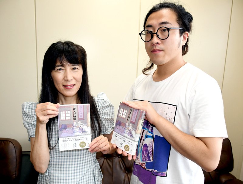 表紙や挿絵の２５枚を担当した柳瀬さんの著書「親父の納棺」を紹介する日暮えむさん（左）と、どん太さん＝成田市
