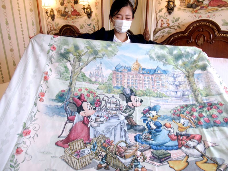 東京ディズニーランドホテルを背景にお茶会を楽しむミッキーマウス、ミニーマウス、ドナルドダック、デイジーダックを描いた掛け布団カバー。永遠不滅のキャラクターだ＝浦安市の東京ディズニーランドホテル