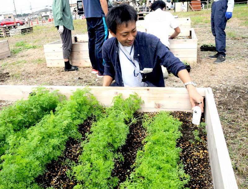 オープンした農園で、栽培ナビゲーションシステムのセンサーを手にする新井代表＝市原市