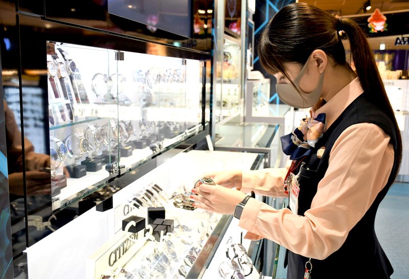 幅広い国の観光客らから購入される腕時計を陳列する免税店のスタッフ＝１１日午後、成田空港
