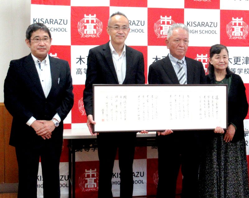 土井晩翠直筆の校歌の色紙を手に持つ山口同窓会長（中央・右）と卯月校長（同・左）（県立木更津高校提供）
