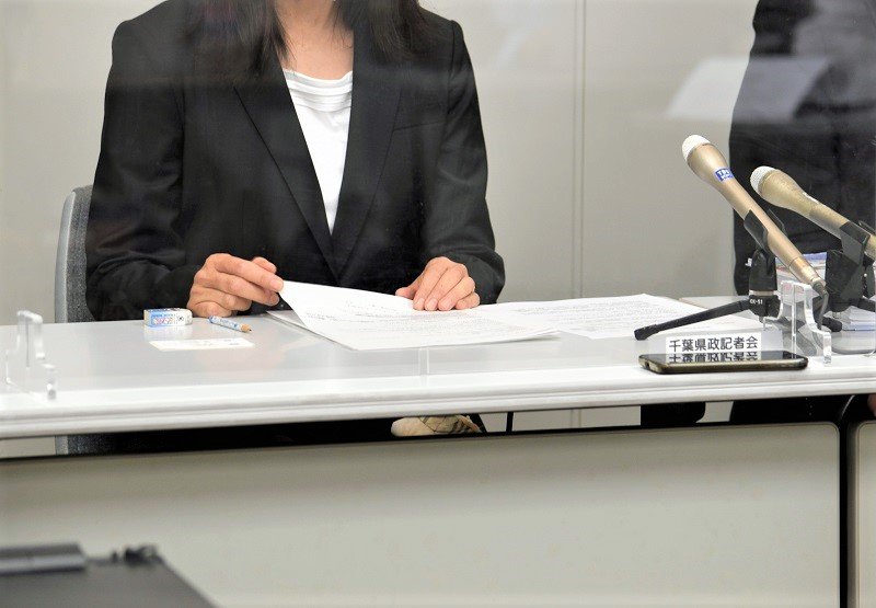 提訴後、記者会見を開いた男性の妻＝２日午後、県庁