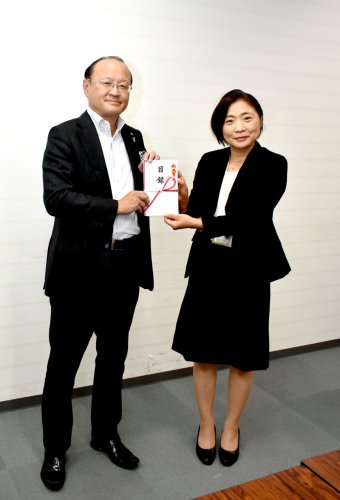 高梨部長（右）に目録を手渡す岡田本部長＝県庁