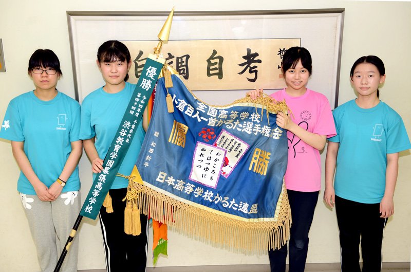 優勝旗を手にする全国大会のメンバー（左から鈴木さん、四十栄さん、服部晶さん、張彦欣さん）＝千葉市美浜区の渋谷幕張高
