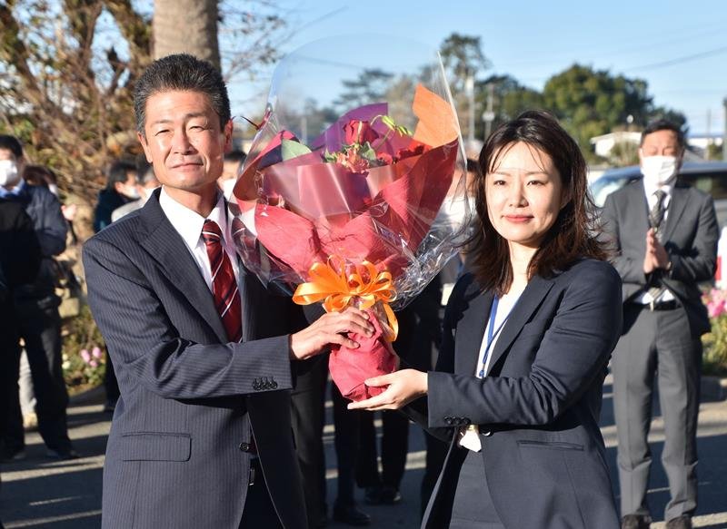 初登庁し、職員から花束を受け取る森市長（左）＝１９日、館山市役所
