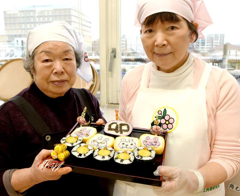 今年の干支（えと）、ウサギの太巻き寿司を手にする三橋さん（右）と亀の寿司を作った川野泰子さん