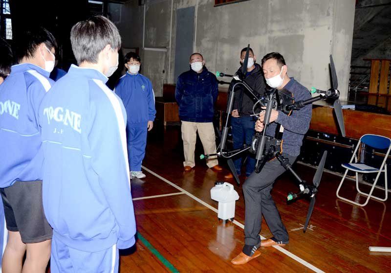 農薬散布用の大型ドローンについて説明する小川社長＝東金市