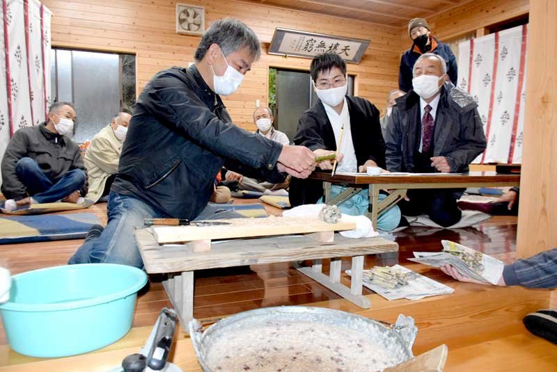 竹を割って米や小豆の分量を確かめる松山義仁宮司（中央）ら＝１５日、匝瑳市の松山神社