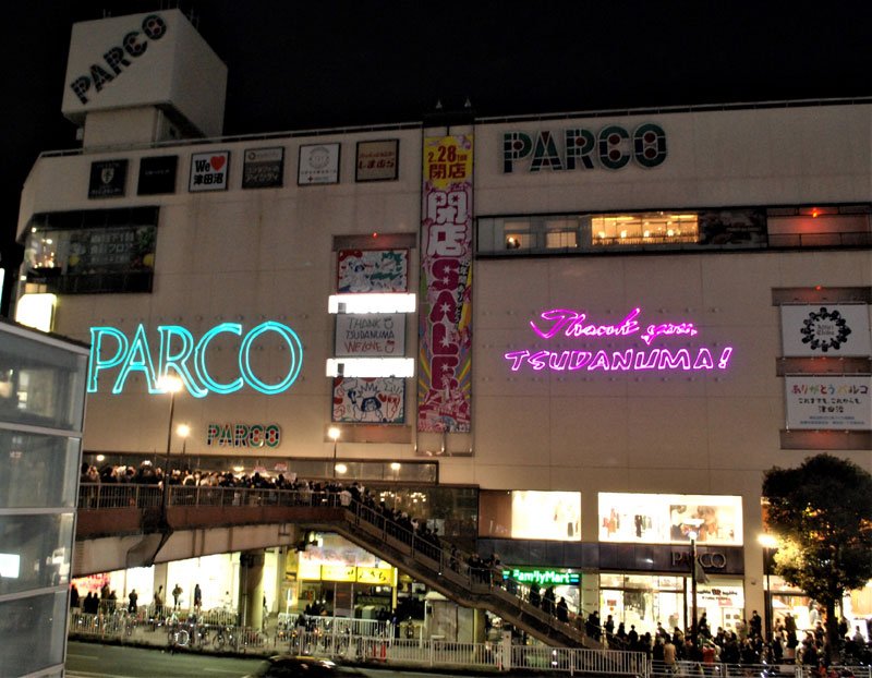 多くの人が見守る中、壁に「サンキュー・ツダヌマ」と映し出して閉店の別れを告げた津田沼パルコ＝２８日午後９時ごろ
