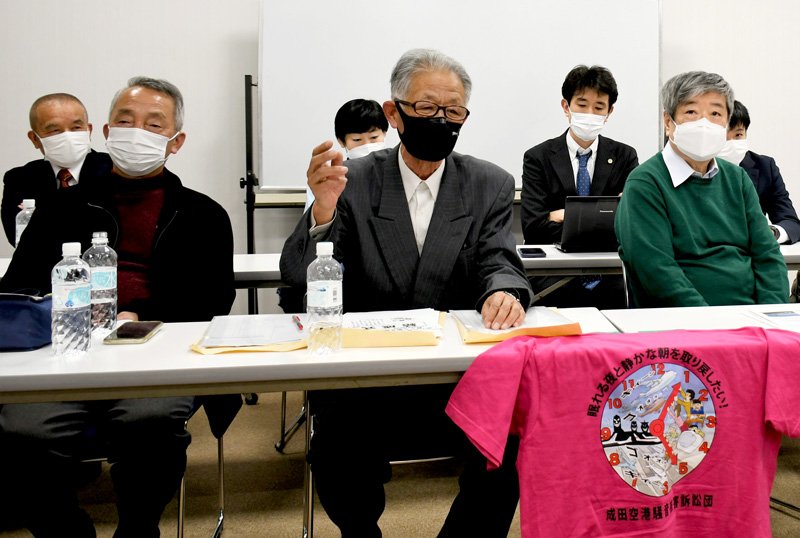 記者会見で「とにかく眠れる夜と静かな朝を取り戻したい」と訴える訴訟団長の加藤さん（中央）＝２６日、成田市