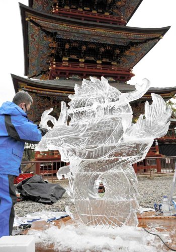 きれいな曲線が際立つ竜の氷彫刻を仕上げる職人＝５日、成田市の成田山新勝寺
