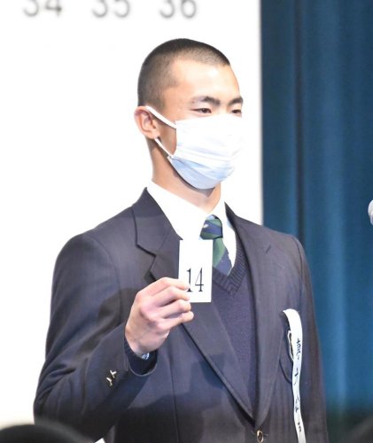抽選会で引いた「１４」の番号札を読み上げる専大松戸の大森主将＝大阪市内
