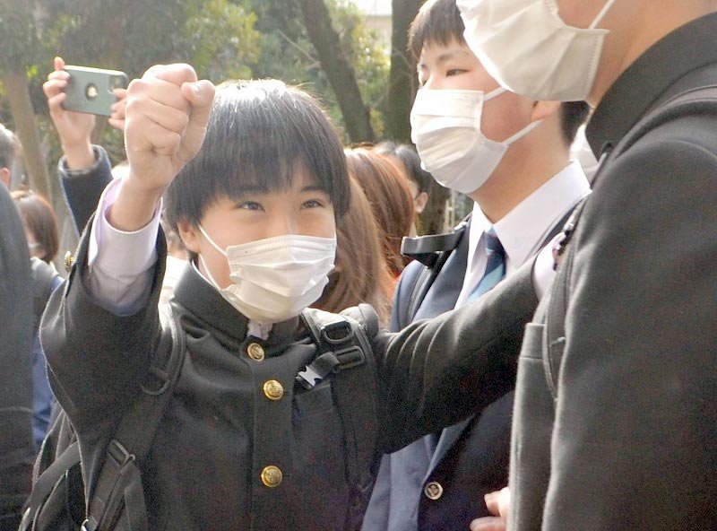 合格者番号を確認し喜ぶ受験生＝３日午前９時ごろ、千葉市中央区の県立千葉高校