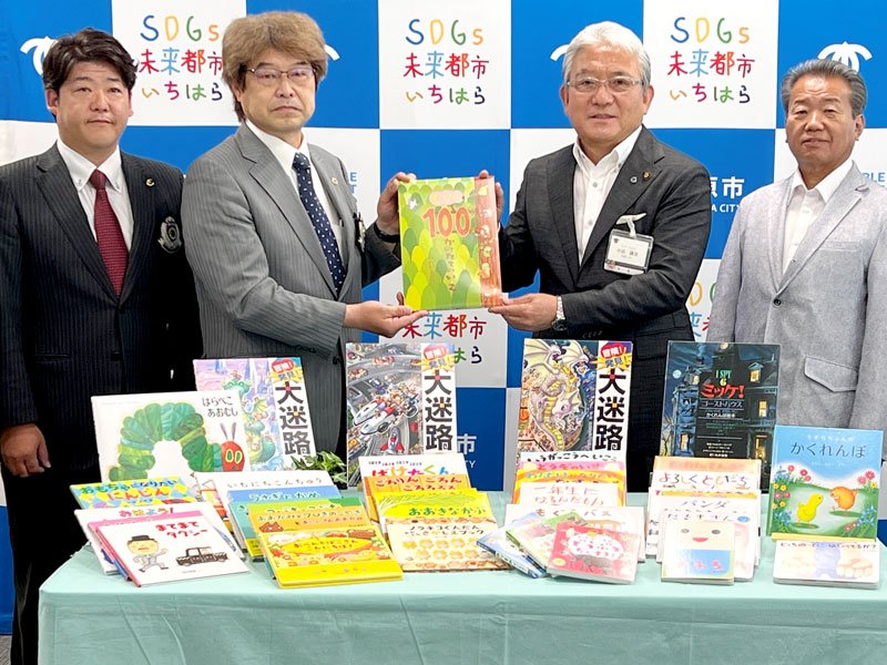 贈呈式で小出市長（右から２人目）に絵本を手渡す市原かずさＬＣのメンバー＝市原市役所