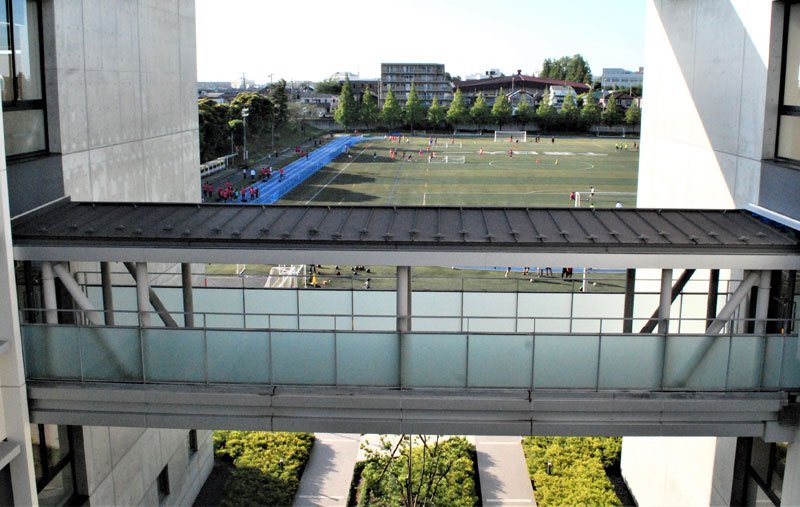 中学校棟（左）と高校棟の回廊から望むグラウンド。学校敷地全体は約８万５千平方メートルの広さ
