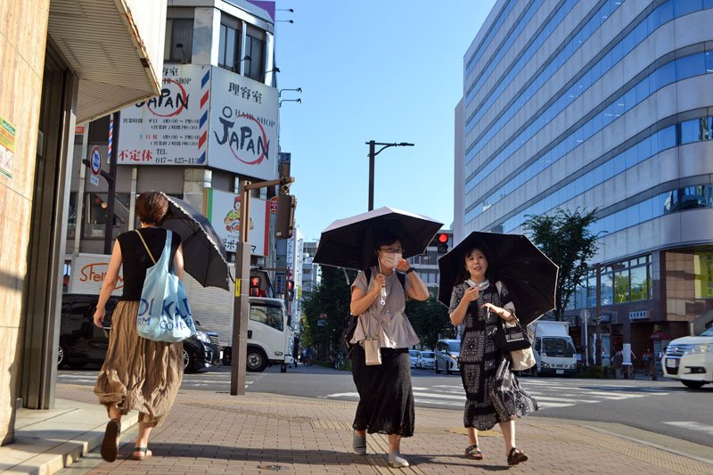 日傘を差して歩く人たち＝２６日午後４時ごろ、船橋市