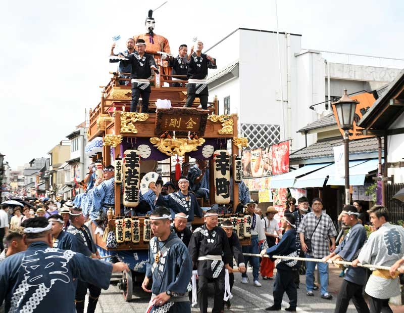 成田山参道で力強く山車を引き回す人々＝７日、成田市