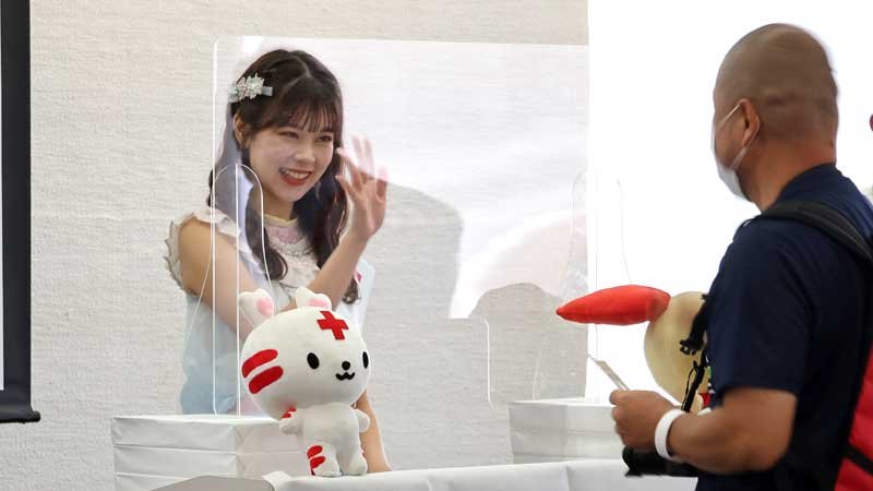 ファンに記念品を手渡した吉川さん（左）＝２０日、千葉市中央区の県赤十字会館