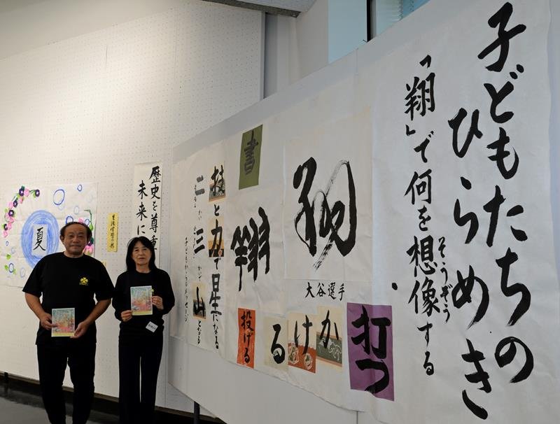 開催中の「なの花書道展」で、来場を呼びかける金子代表（右）＝千葉市中央区の県立美術館
