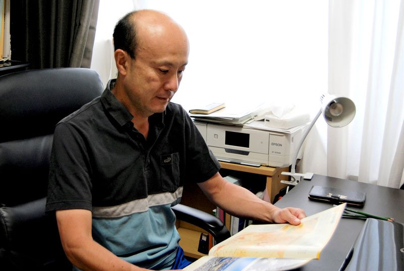 千葉空襲の資料に目を通す増田さん＝千葉市中央区