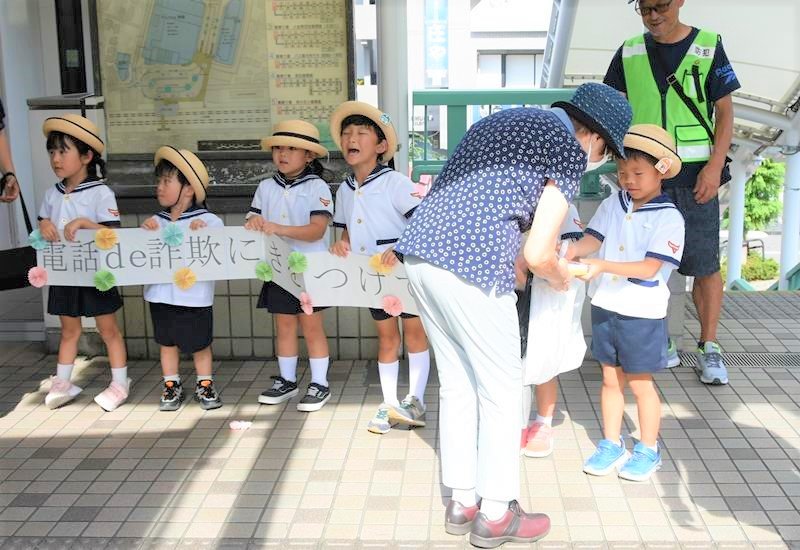 ＪＲ北小金駅で啓発グッズを渡す園児たち＝松戸市
