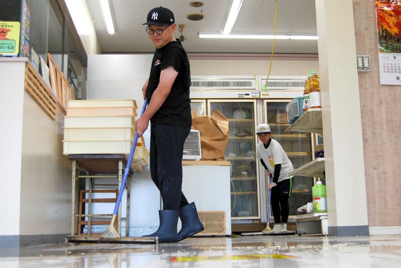 店内に入り込んだ泥水をかき出す男性ら＝９日午前１０時４０分ごろ、長柄町鴇谷