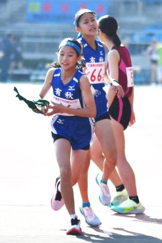 有秋２区の山本愛珠（中央）から３区の露崎花梨（左）へ１位でたすきリレー＝柏の葉