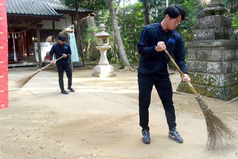 日吉神社の境内を掃除する城西国際大の硬式野球部員ら＝２３日、東金市