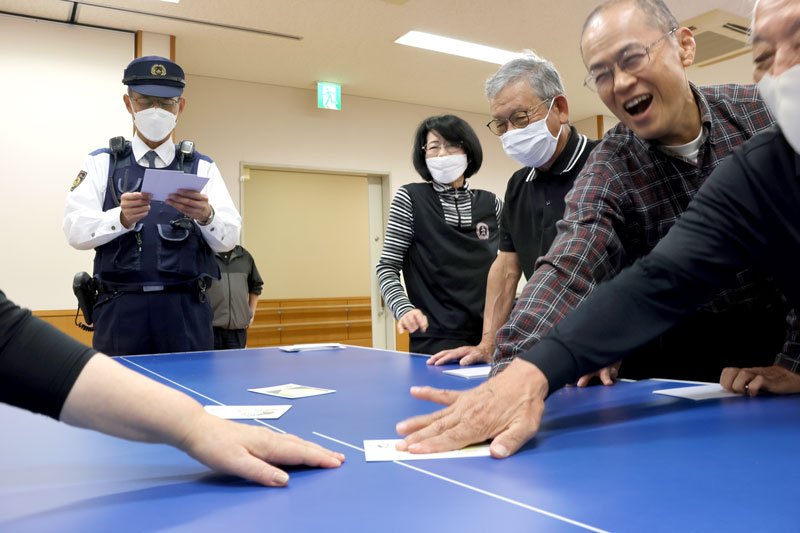 笑顔でかるたに手を伸ばす高齢者＝１１月２７日、千葉市緑区