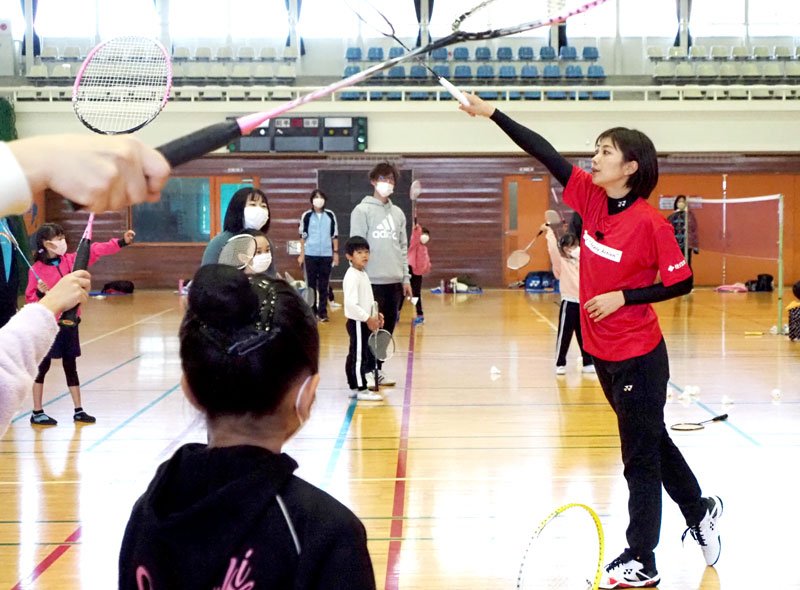 潮田玲子さん（右）からバドミントンの指導を受ける親子＝木更津市