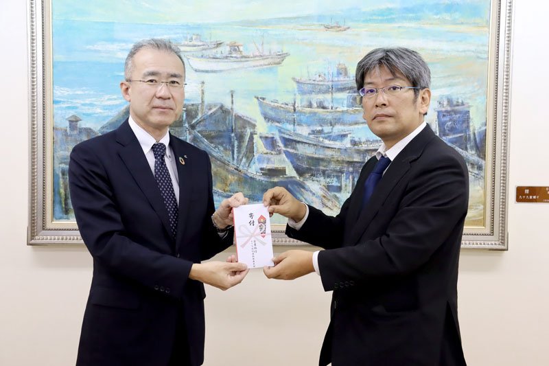 寄付金を託す有賀推進本部長（左）