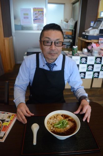 二段仕込みしょうゆを使った看板商品「富士虎（黒）」をアピールする鈴木さん＝山武市
