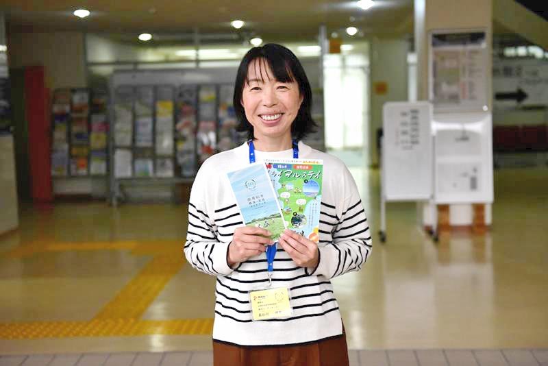 移住に関するパンフレットを紹介する長谷川さん＝南房総市役所
