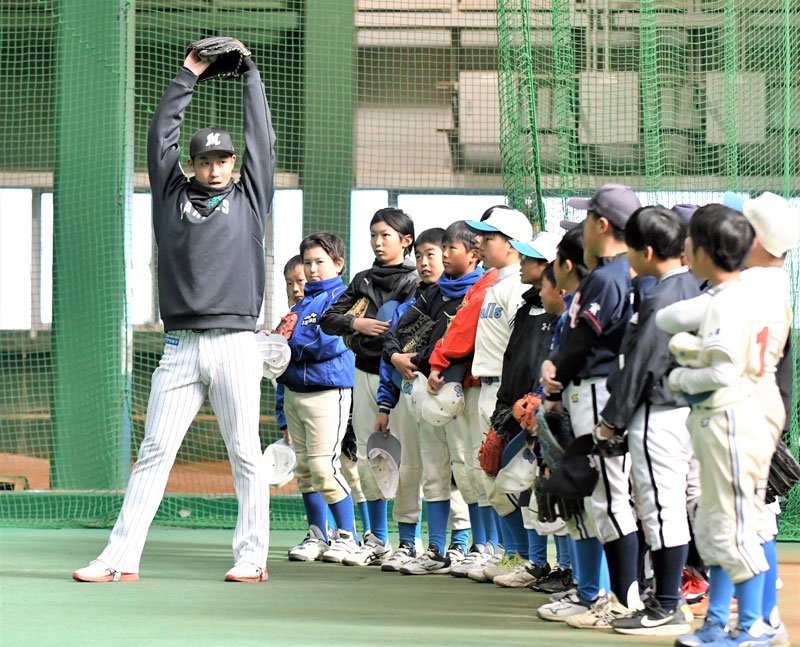 「体を大きく使って投げよう」と指導する千葉ロッテの菊地選手＝１４日、千葉市美浜区
