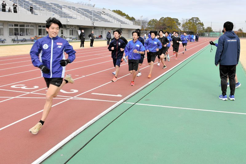 順大の吉岡選手（左）らをペースメーカーにして「ビルドアップ走」に挑戦する中学生＝２８日、印西市の松山下公園陸上競技場