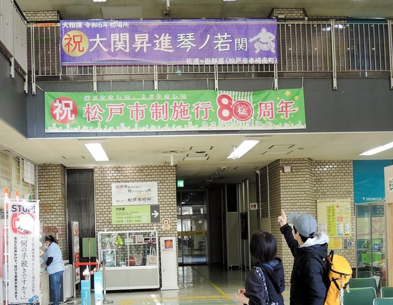 大関昇進を祝う横断幕に市民らが見入った＝３１日、松戸市
