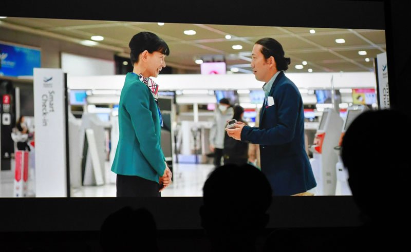 成田空港関連企業による合同就職説明会で初上映された「空の港のありがとう」。旅客がなくした指輪を清水さん演じる地上係員（左）が手渡すシーン＝６日、千葉市美浜区の幕張メッセ
