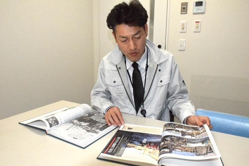広報広聴班時代に発行された「広報あさひ」を開く石田喜宏さん＝旭市