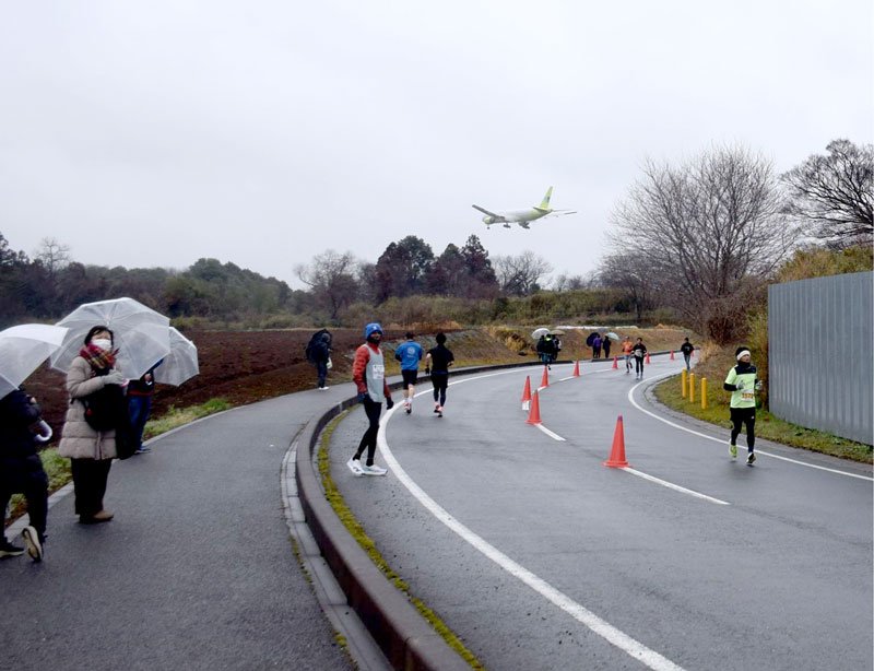 離着陸する飛行機を眺めながら快走するランナー＝芝山町