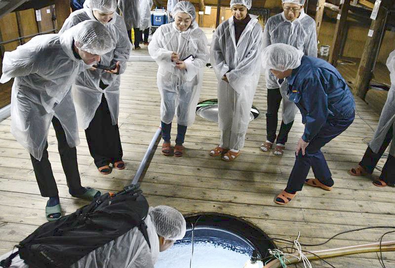 酒蔵で、もろみタンクをのぞき込む一橋大の留学生たち＝神崎町

