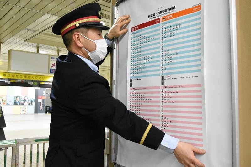 １６日から実施のＪＲ京葉線ダイヤ改正に伴い、新習志野駅で終電後に時刻表を張り替える駅員＝同日午前１時１５分ごろ、習志野市