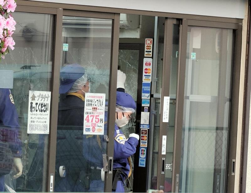 強盗事件のあった質店で鑑識作業を行う警察官ら＝２５日午後、八千代市八千代台南