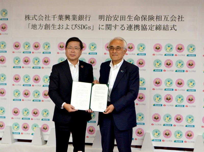 連携協定を締結した千葉興銀の梅田頭取（左）と明治安田生命保険の根岸会長＝千葉市美浜区