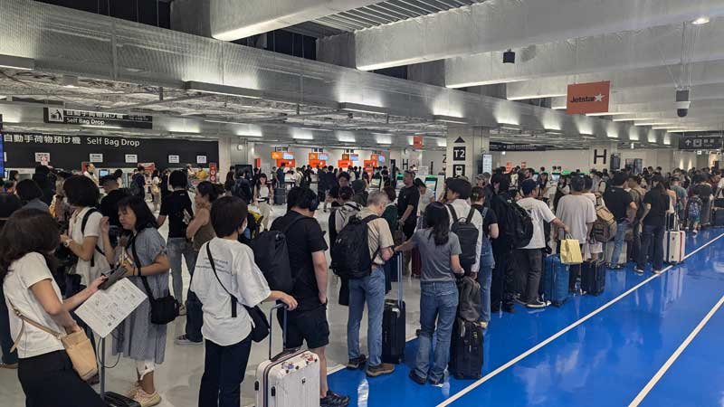 旅客の長い列ができた成田空港第３ターミナルの搭乗ゲート＝１９日、成田市